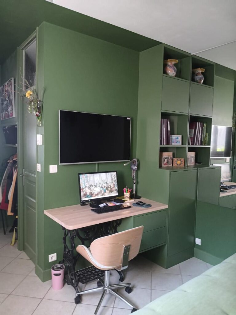 Aménagement Bureau Vert et Design Vintage en Bois Bureau vert avec plan de travail en bois sur pied vintage, écran TV et étagères murales intégrées.